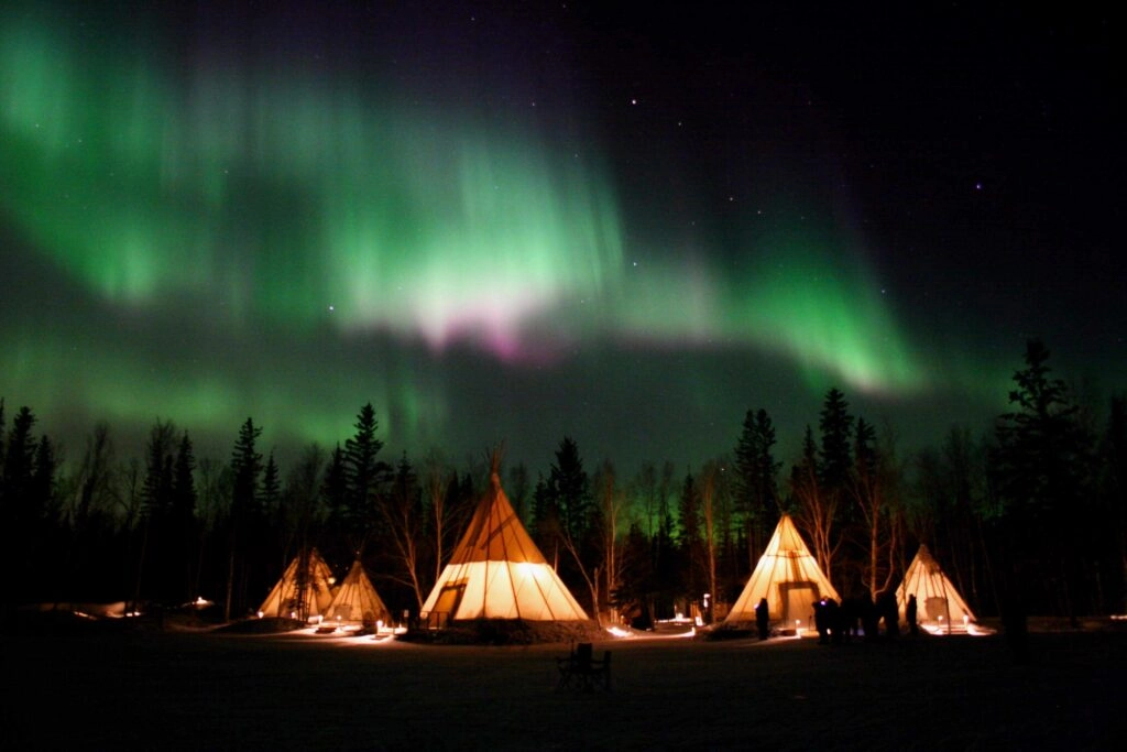 Aurora village yellowknife northwest territories canada aurora borealis northern lights winter teepees colourful pink hero perfect
