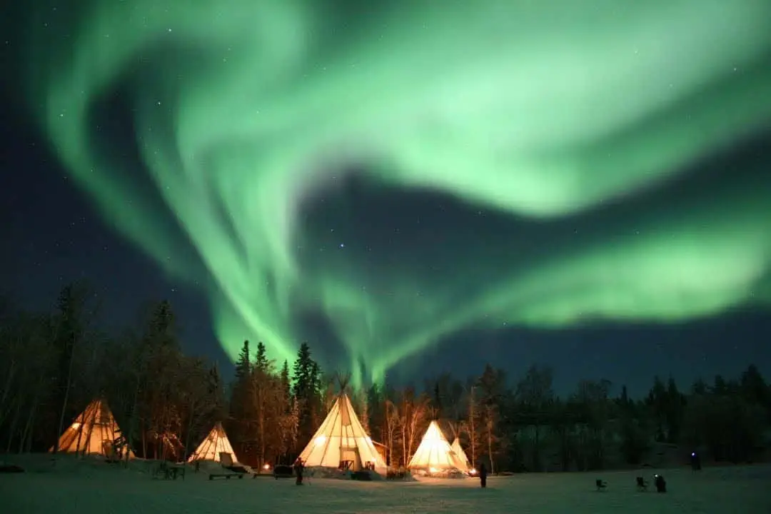 Aurora village yellowknife northwest territories canada aurora borealis northern lights winter landscape colourful green five teepees hero